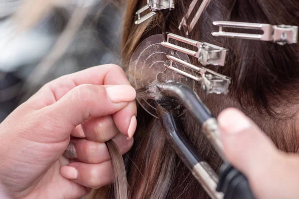 Profesjonalny proces przedłużania włosów dla kobiety z pomocą — Zdjęcie stockowe