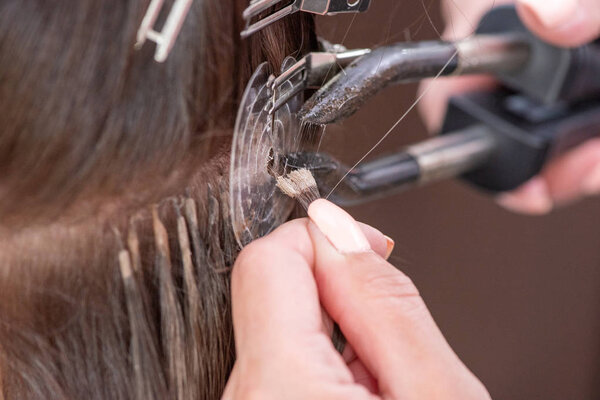 Профессиональный процесс наращивания волос для женщины с помощью
