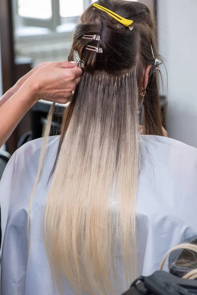 Professional process of hair extension for a woman with the help
