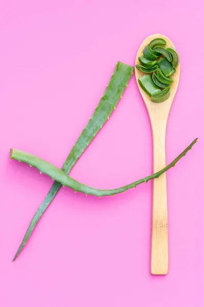 Plante médicinale aloe vera sur une cuillère en bois sur un fond rose — Photo