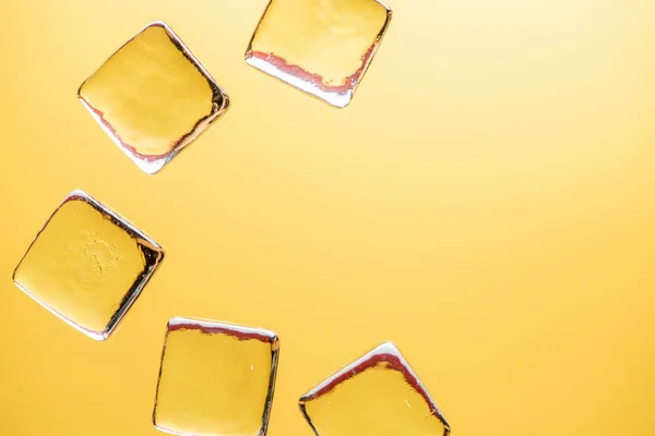 Stylish yellow background with transparent ice-like cubes for dr — Stock Photo, Image