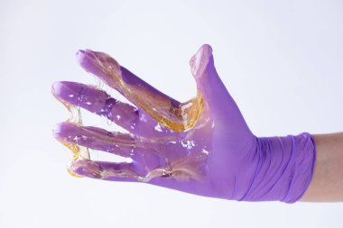 Bir eldiven kadın eli depi için sarı şeker hamuru veya balmumu tutar