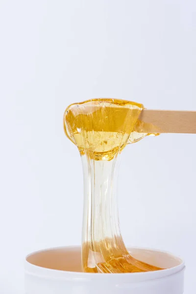 Pasta di zucchero giallo liquido o cera per depilazione su un bastone vicino — Foto Stock