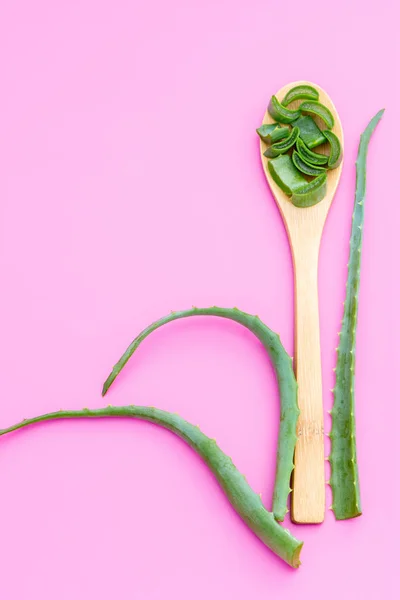 Plante médicinale aloe vera sur une cuillère en bois sur un fond rose — Photo