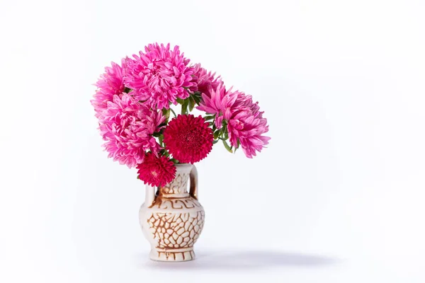 Beautiful bouquet of pink and red flowers asters in a ceramic ju