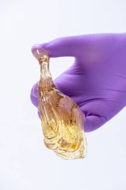 Bir eldiven kadın eli depi için sarı şeker hamuru veya balmumu tutar