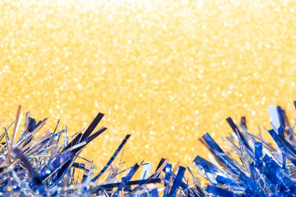 Schönes blaues Lametta auf leuchtend gelbem Glitzerhintergrund für fes — Stockfoto