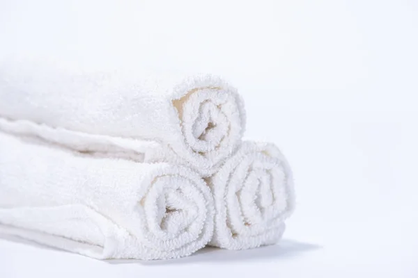 Toallas de rizo suavemente enrolladas para spa o masaje en un fondo blanco — Foto de Stock