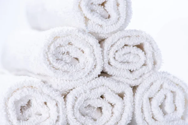 Gently rolled terry towels for spa or massage on a white backgro