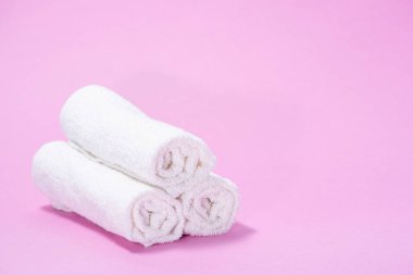 Yavaşça pembe bir backgrou spa veya masaj için terry havlu haddelenmiş