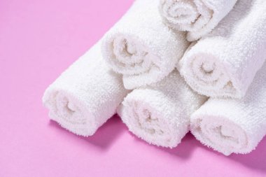 Yavaşça pembe bir backgrou spa veya masaj için terry havlu haddelenmiş