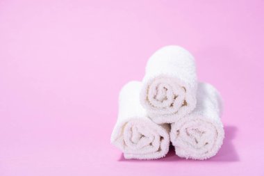 Yavaşça pembe bir backgrou spa veya masaj için terry havlu haddelenmiş
