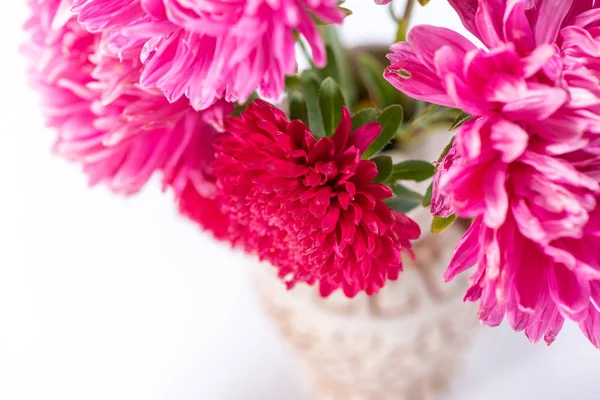 Beautiful bouquet of pink and red flowers asters in a ceramic ju