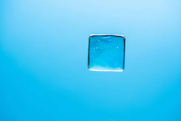 Stylish blue background with transparent ice-like cubes for drin