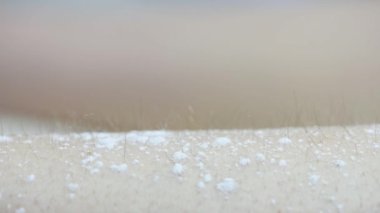 Bir kadının bacaklarındaki kılları ağda yaparak aldırma prosedürünün aşamalarından birine yakın çekim.