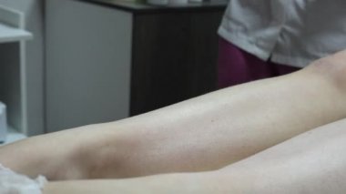 Bir kadının bacaklarındaki kılları ağda yaparak aldırma prosedürünün aşamalarından birine yakın çekim.