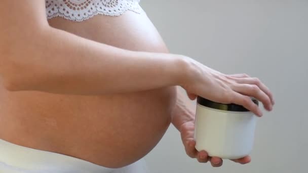 Κοντινό Πλάνο Ενός Έγκυου Κοριτσιού Τρίβει Ραγάδες Κρέμα Στο Δέρμα — Αρχείο Βίντεο