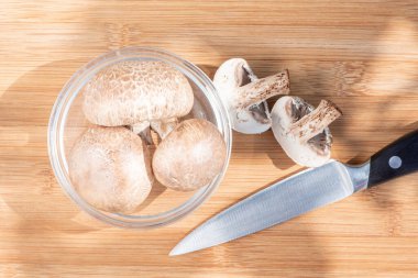 Kahverengi orman mantarları şampiyonları tahtanın üzerinde solucanlarla ikiye bölünmüş.