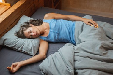 Huzurlu ve huzurlu bir görüntü. Huzurlu bir kadın. Rahat ve davetkar bir yatak odasında uyuyor.