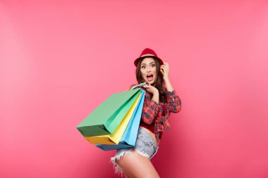 renkli alışveriş torbaları pembe arka plan, alışveriş ve indirim kavramı karşı poz olan kadın