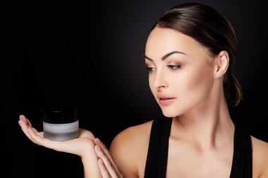 güzellik kavramı, baş ve omuzlar krem elinde siyah arka planda tutan güzel genç kadın portresi