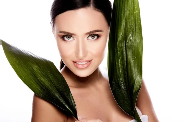 水の皮膚 皮膚ケア概念灰色の背景で緑の葉でポーズ美しいと自然の若い女性 — ストック写真