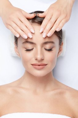 yüz, Cilt Bakımı, spa yordam ve rahatlatıcı kavramı üzerinde eller ile mükemmel cilt yüz masajı, sahip genç kadın 