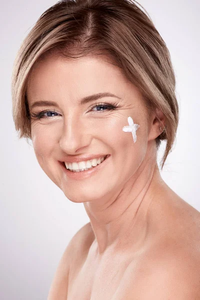 肌にクリーム 美容写真の概念 肌やしわの治療 紫外線保護 プラス記号を使用して裸の肩を持つのはかなり笑顔の若い女性 — ストック写真