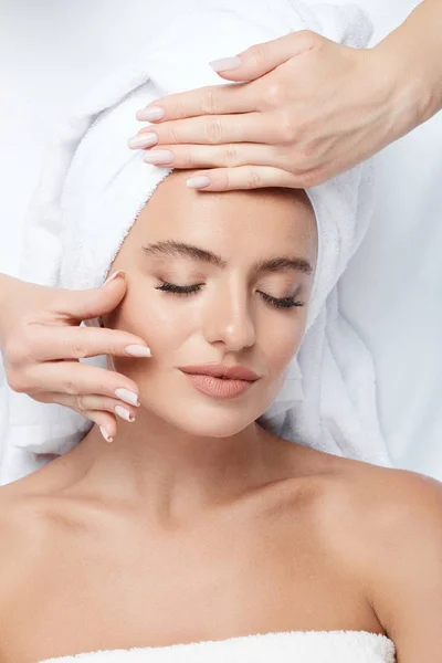 yüz, Cilt Bakımı, spa yordam ve rahatlatıcı kavramı üzerinde eller ile mükemmel cilt yüz masajı, sahip genç kadın 