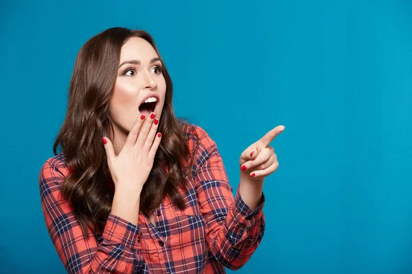 Nette Junge Frau Zeigt Auf Etwas Vor Blauem Hintergrund — Stockfoto