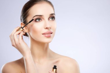 maskara, kopya alanı, gri arka plan kullanarak muhteşem bir genç kadın 