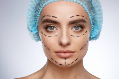 gülümseyen kadın, estetik ameliyat kavramı güzellik portresi. Yüzündeki ponksiyon çizgili mavi şapkalı model