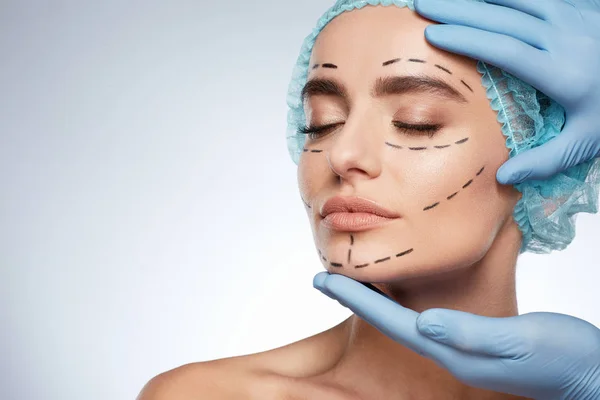 美容整形手術概念の女性の肖像画 モデルの顔に穿刺ラインとブルー キャップ — ストック写真