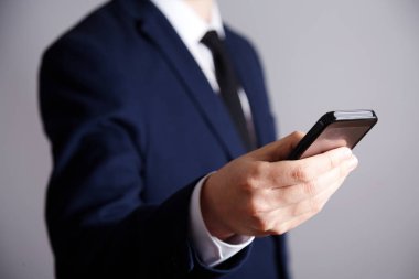 çekici bir adam cep telefonu, iş kavramı holding takım elbise