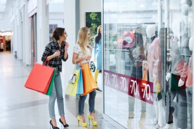 renkli alışveriş torbaları alışveriş merkezi dükkan pencerede bakarak ile genç ve güzel kadınlar 