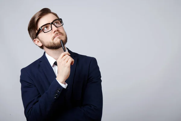 Nadenkend Man Met Pak Bril Tegen Grijze Achtergrond — Stockfoto