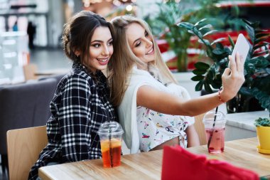 kokteyl içme ve selfie alışveriş sonra alarak kafede çekici genç kadın 