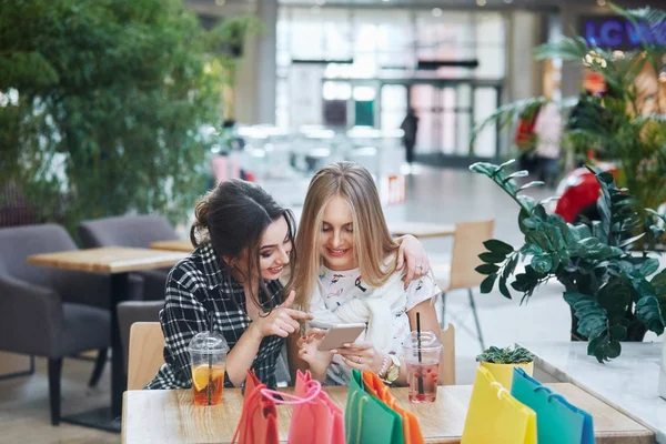 akıllı telefonlar, kafede masada çanta alışveriş renkli kullanarak çekici genç kadın