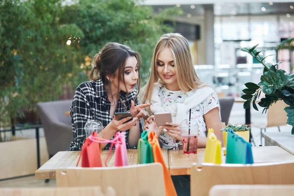 Attractive Young Women Using Smartphones Colorful Shopping Bags Table Cafe — Stock Photo, Image