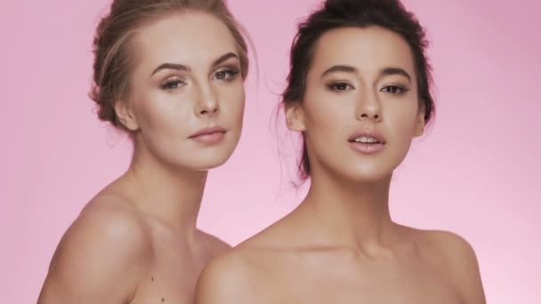 Симпатичные девушки позируют на розовом фоне — стоковое видео