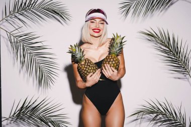 Kırmızı dudaklar ayakta beyaz stüdyo arka plan adlı iki ananas ile gülümseyen çekici kızı