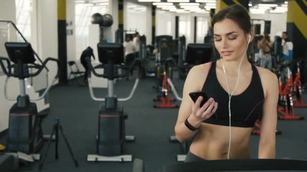 Härlig passform flicka kör på gym bakgrund — Stockvideo
