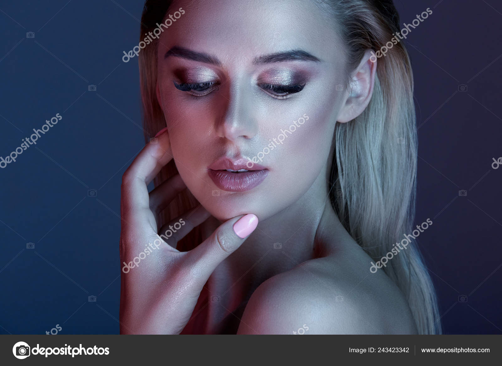 Pretty Girl With Make Up And Blonde Hair Posing With At Dark Blue