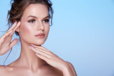 mavi arka plan üzerinde poz çıplak makyaj ile çekici genç kadın portresi