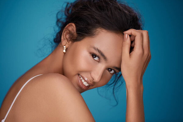 Красивая молодая девушка с голым макияжем позирует на фиолетовом фоне
