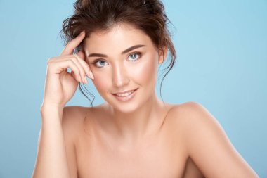 young attractive woman with bare shoulders on blue background