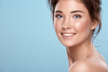 young attractive woman with bare shoulders on blue background