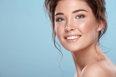 young attractive woman with bare shoulders on blue background
