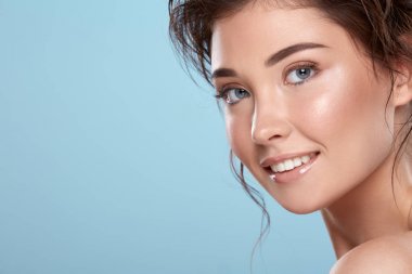 young attractive woman with bare shoulders on blue background