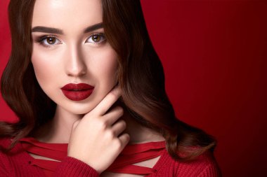 kırmızı arka plan üzerinde akşam makyaj ile çekici genç kadın